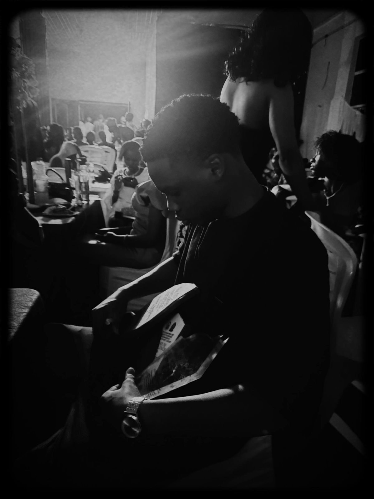 Black-and-white photo from awards night: holding an award plaque, head bowed